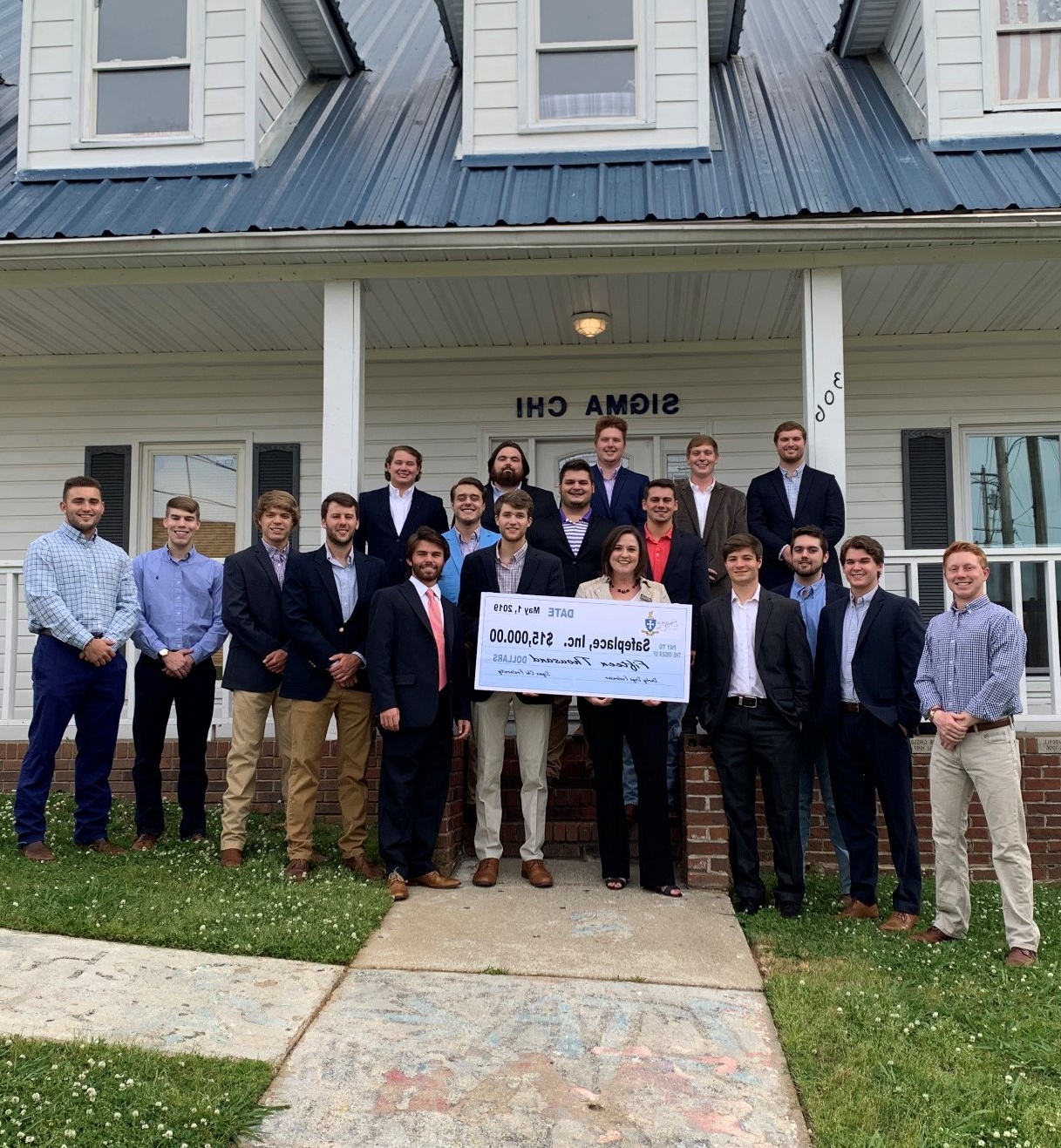 The brothers of sigma chi stand outside their house with a representative from Safe Place, presneting the charity with a $15,000 check from the fraternity's derby days competition.