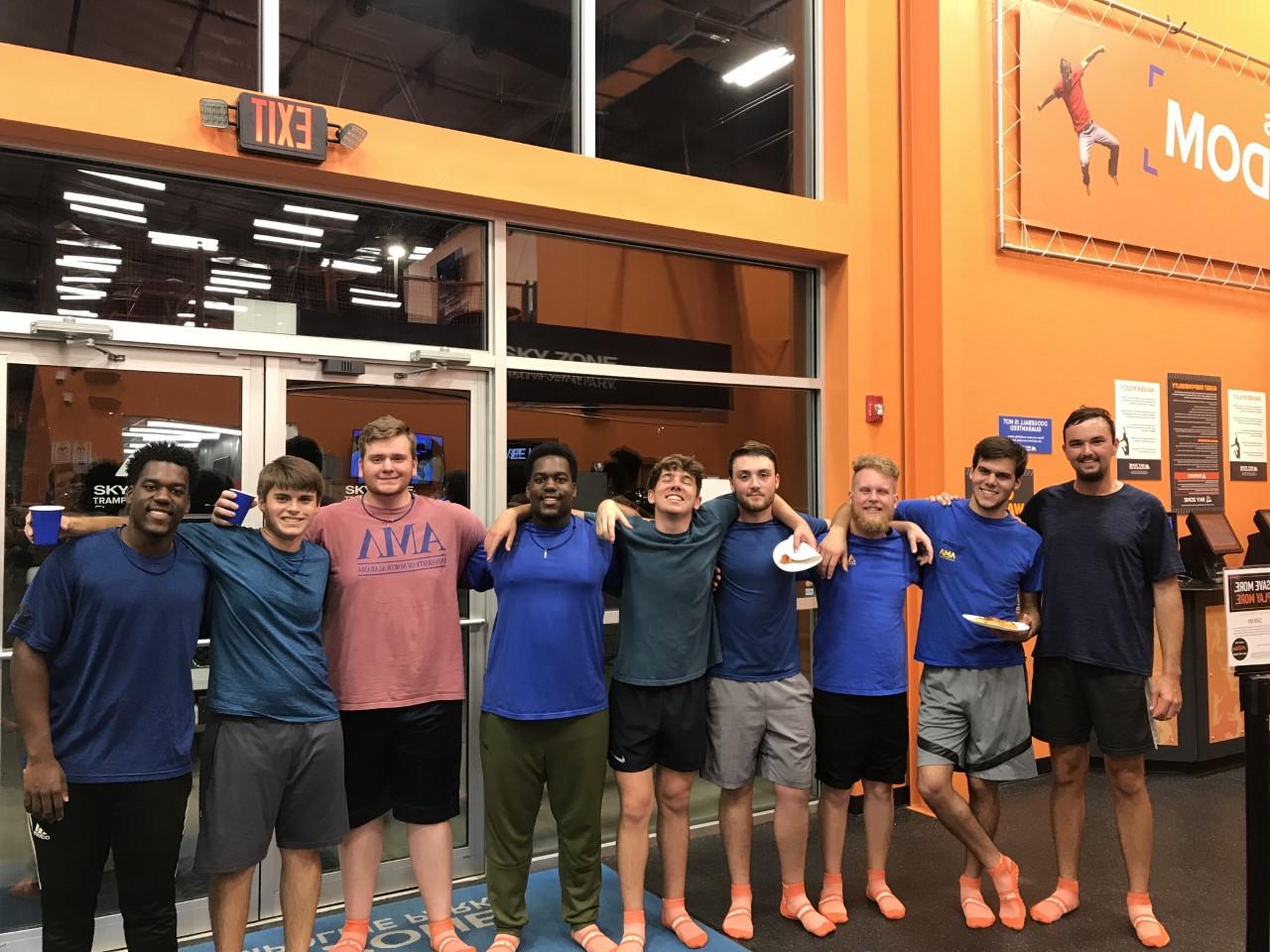 Members of AML smile together at SkyZone. 